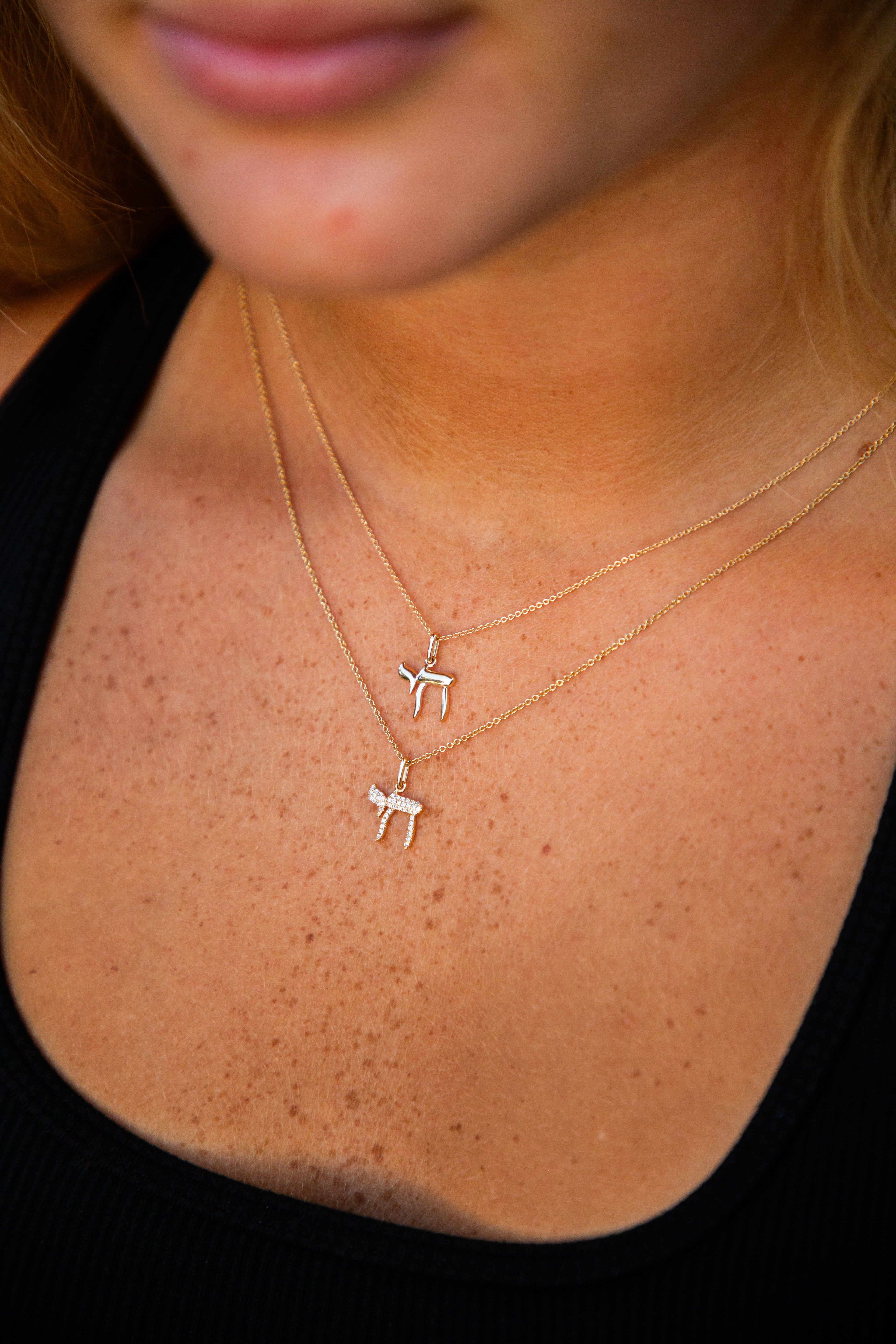 person wearing a gold chai necklace
