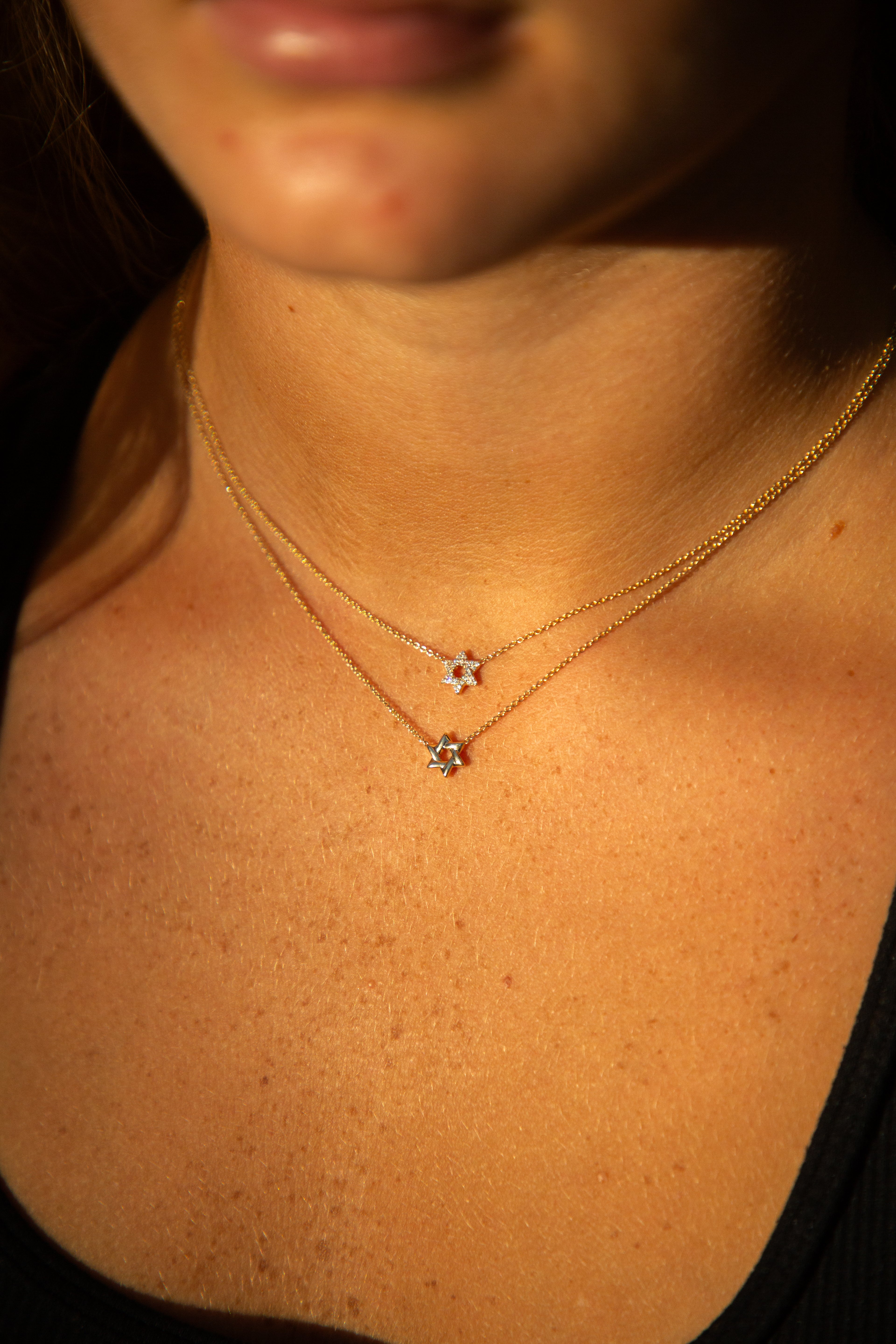 person wearing two gold necklaces