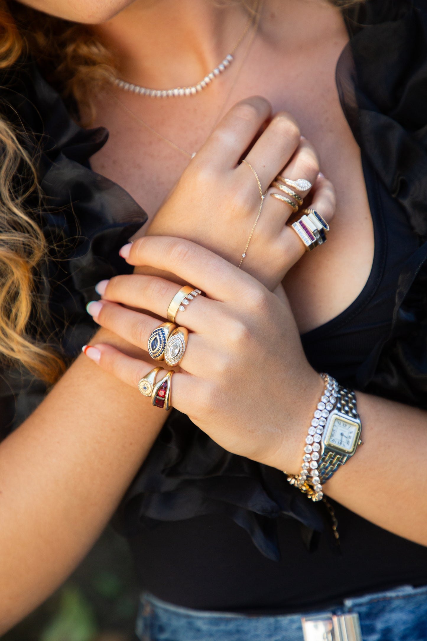Close-up of hands with multiple rings and a watch