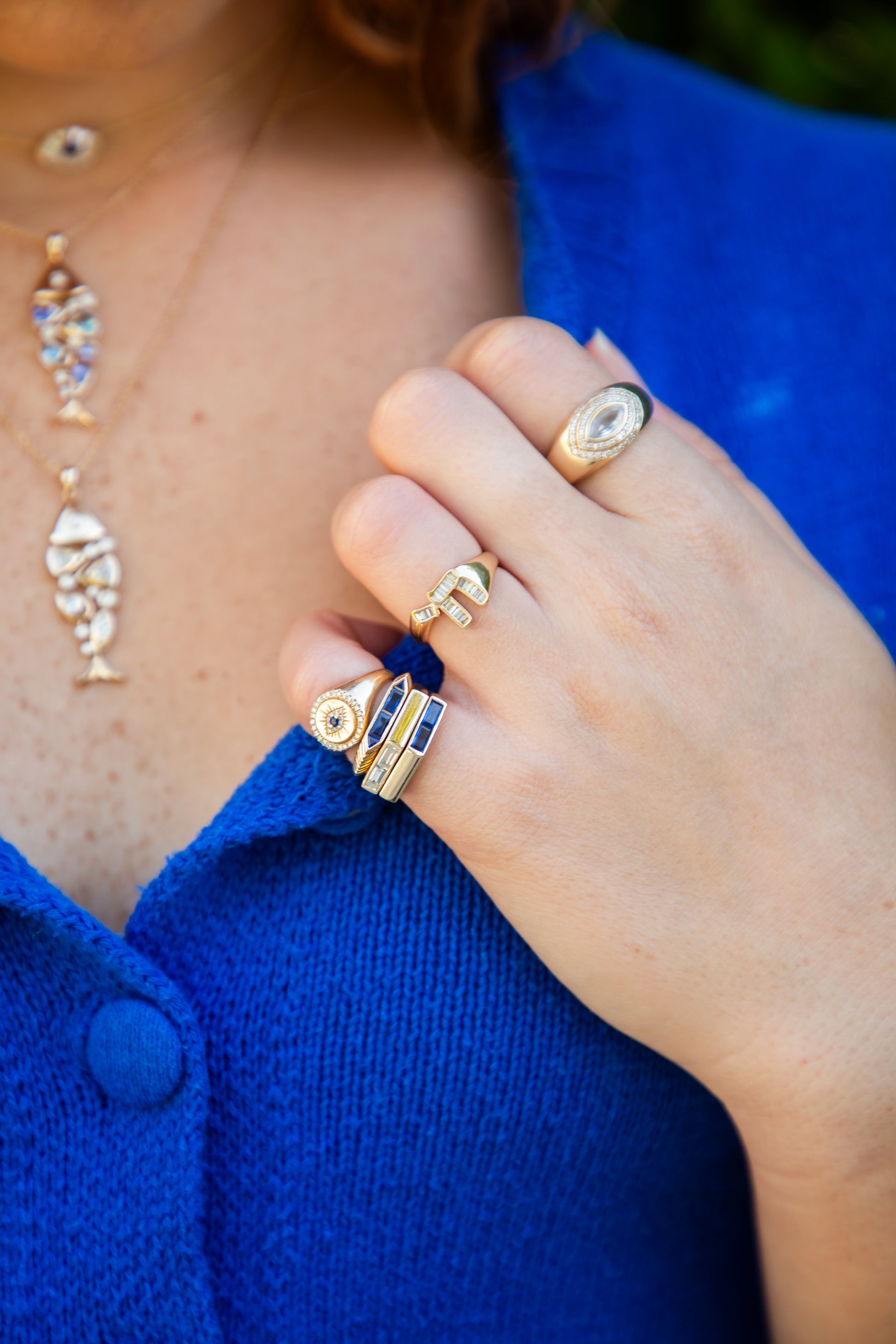 Close-up of a hand wearing multiple gold rings 
